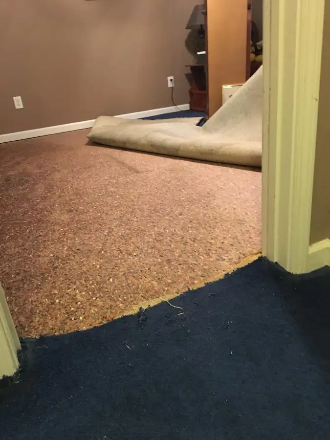Carpet pad removal revealing water damage during Water Mitigation Services in Aransas Pass
